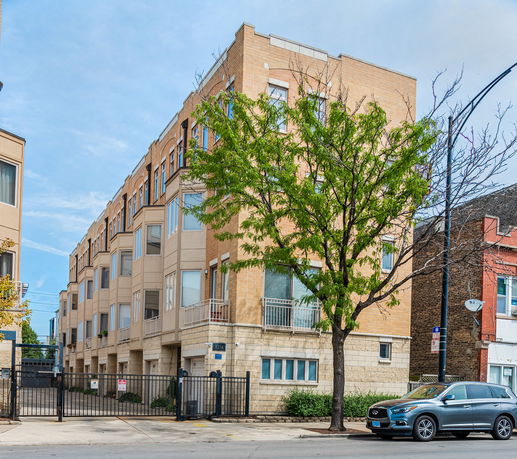 Front view of a multi-story building with a gated entrance.