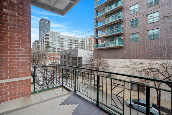 View from a balcony overlooking surrounding buildings and a street.