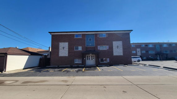 Front view of a three-story brick building with a symmetrical design.