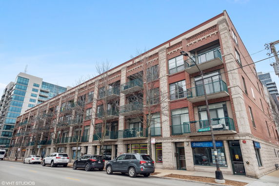 Front view of a multi-story brick and stone building with balconies.