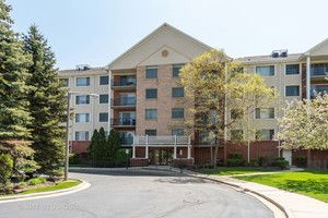 Front view of a multi-story residential building with balconies and entrance.