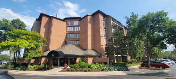 Front view of a multi-story brick building with a covered entrance.