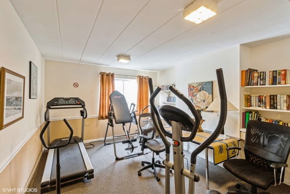 Room with exercise equipment and bookshelves