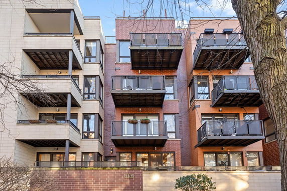 Front view of a multi-story apartment building with balconies.