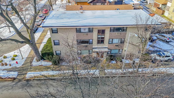 Aerial view of a three-story residential building with winter surroundings.