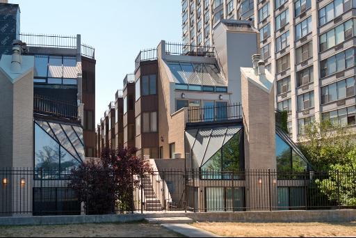 Front view of modern multi-story residential buildings with large glass windows and brick facades.