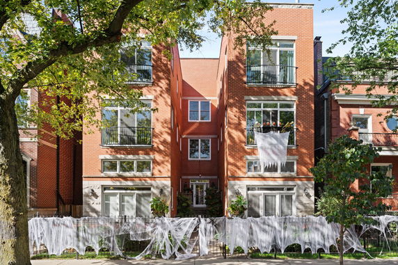 Front view of a multi-story brick building with large windows and a decorative facade.