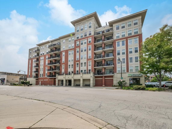 Front view of a multi-story apartment building with balconies.