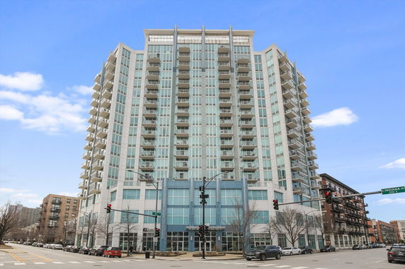 Front view of a high-rise residential building with multiple balconies.