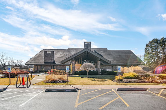 Front view of a building with a large roof and central entrance.