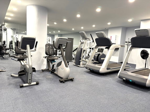 Indoor gym area with exercise equipment including treadmills and stationary bikes.
