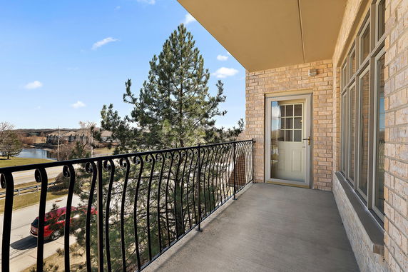 Outdoor balcony with metal railing overlooking surrounding area.