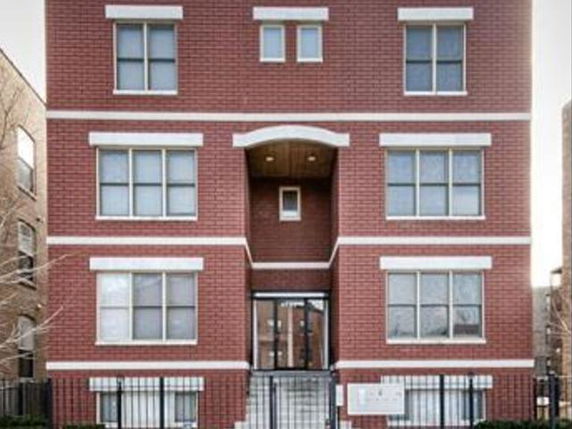 Front view of a multi-story brick building with multiple windows.