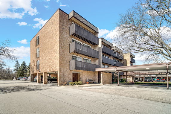 Front view of a multi-story building with balconies and a brick facade.