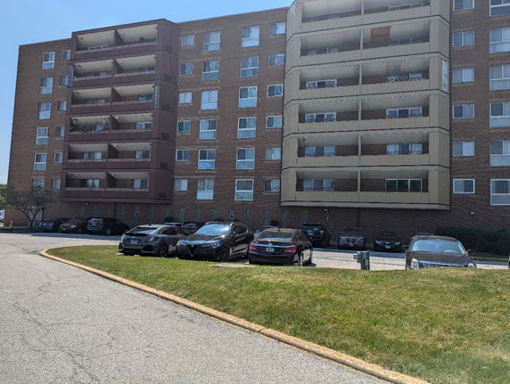 Front view of a multi-story apartment building with balconies.