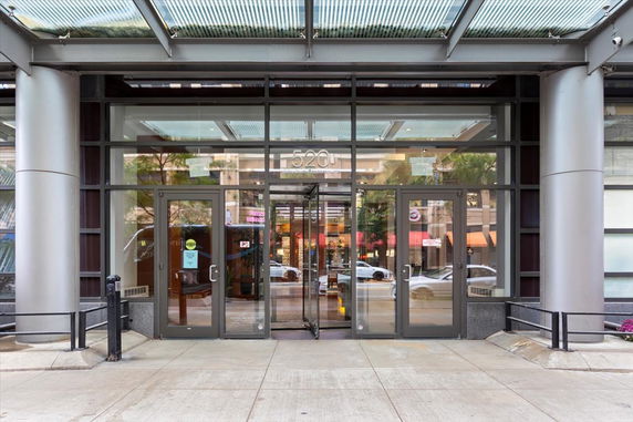 Front view of a building entrance with glass doors and a canopy.