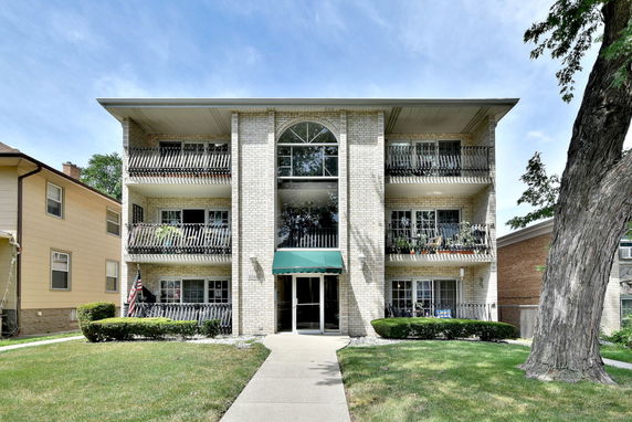 Front view of a three-story apartment building with balconies.