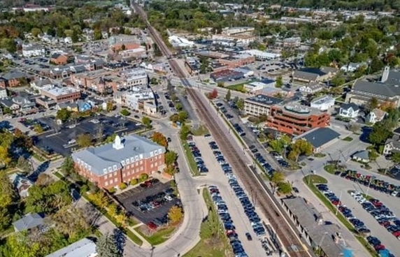Aerial view of a town with streets, parking areas, and multiple buildings.