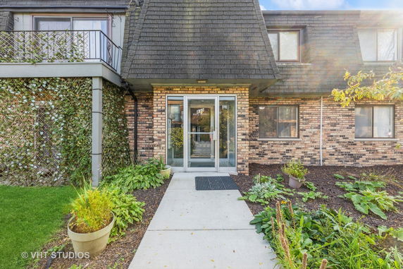 Front view of a brick house with a sloped roof and entrance door.