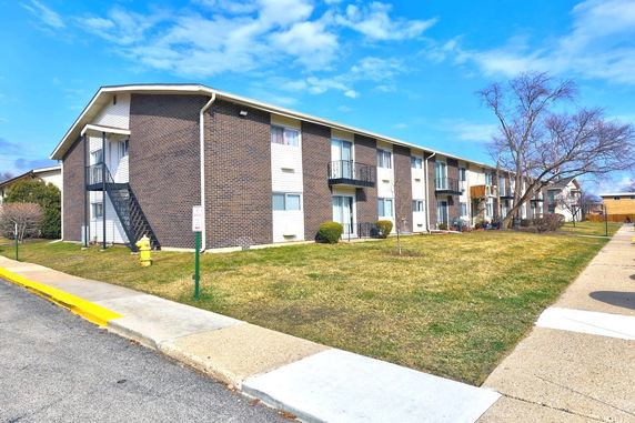 Front view of a two-story apartment building with brick and siding exterior.