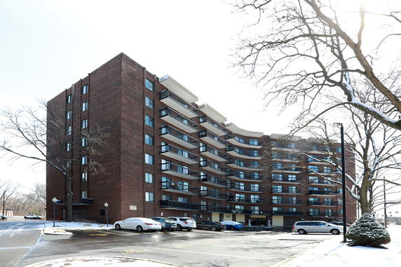 Front view of a multi-story apartment building with balconies.