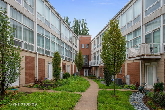 Front view of a multi-story residential building with a courtyard.