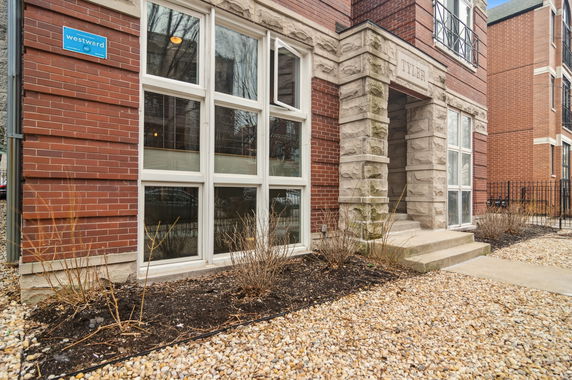 Front view of a brick building with stone accents and large windows.