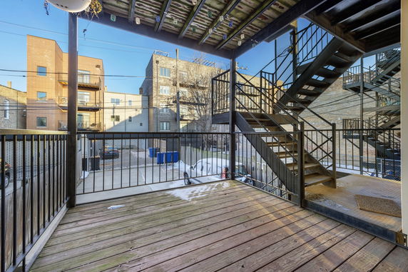 View of a parking area with outdoor stairs and surrounding buildings.