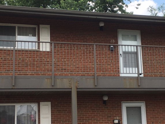 Front view of a two-story brick building with balconies.
