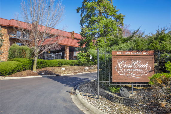 Front view of a condominium complex with a sign reading 'Cress Creek Condominiums'.