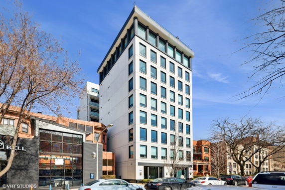 Front view of a modern multi-story building with large windows.