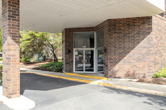 Entrance view of a building with brick walls and glass doors.