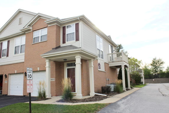 Front view of a two-story brick house with a small balcony.