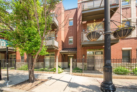 Front view of a brick multi-story residential building with balconies.