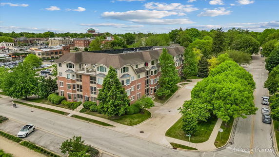 Front view of a multi-story residential building with brick facade and large windows.