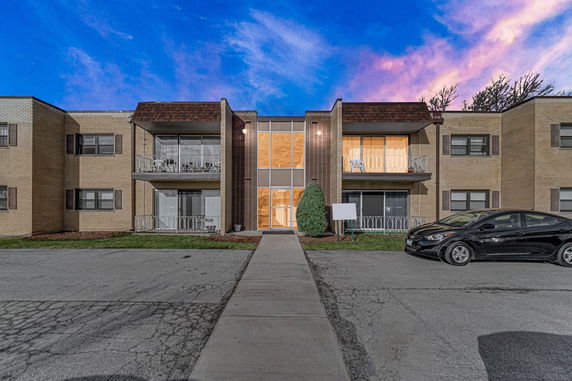 Front view of a two-story apartment building with balconies.