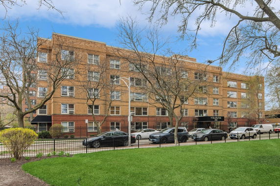 Front view of a multi-story residential building with brick exterior.