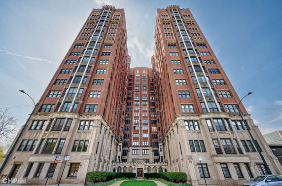 Front view of a high-rise building with a symmetrical design and brick facade.