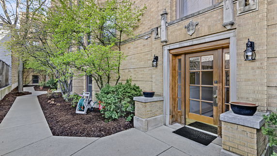 Front view of a brick building with a wooden door entrance.