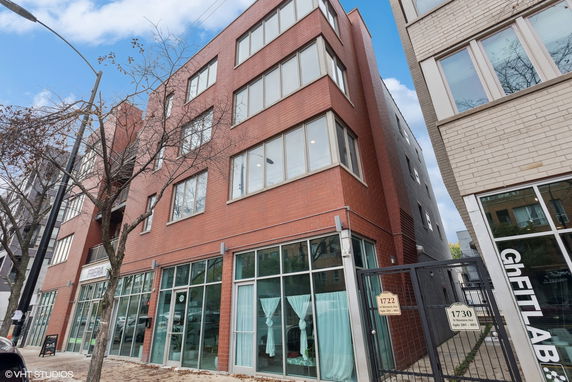 Front view of a multi-story building with large windows and commercial space on the ground level.