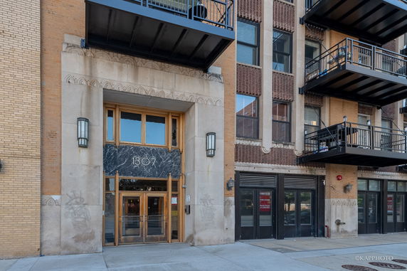 Front view of a multi-story building with balconies and entrance.