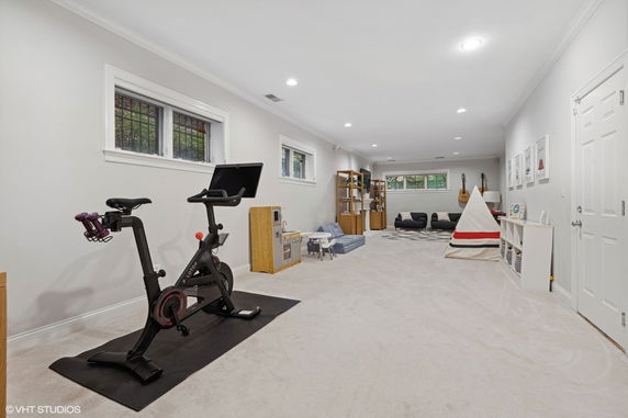 Room with exercise bike, toys, tent, and seating area.