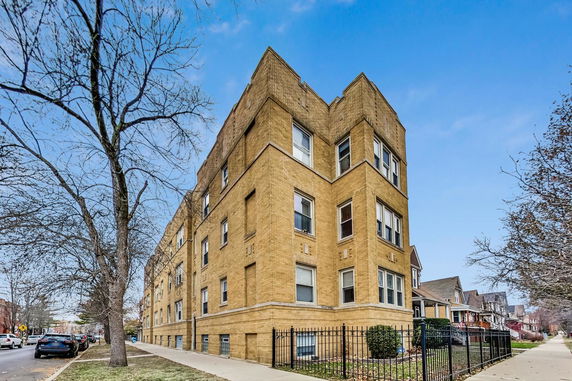 Front view of a multi-story brick building on a corner lot.