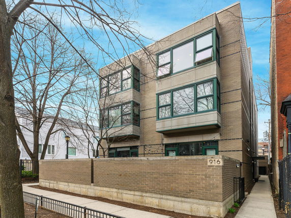 Front view of a modern three-story building with large windows.