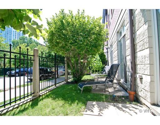 Outdoor patio area next to a building with metal fence and trees.