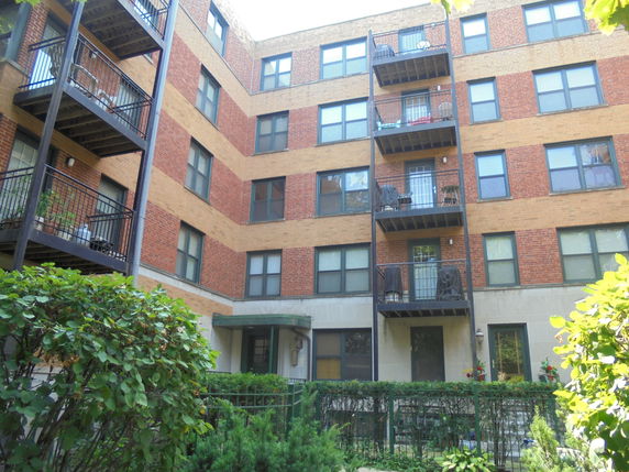 Front view of a multi-story apartment building with balconies.