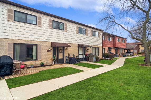 Front view of a two-story townhouse with brick and siding exterior.