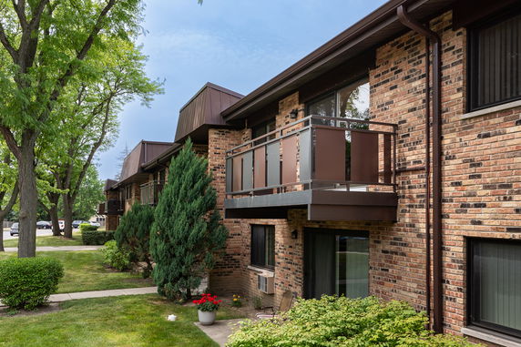 Front view of a two-story building with brick exterior and balconies.