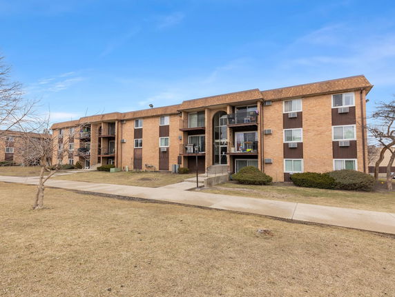 Front view of a multi-story apartment building with balconies.