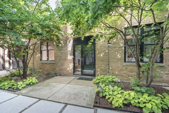 Front view of a house with brick exterior and surrounding greenery.